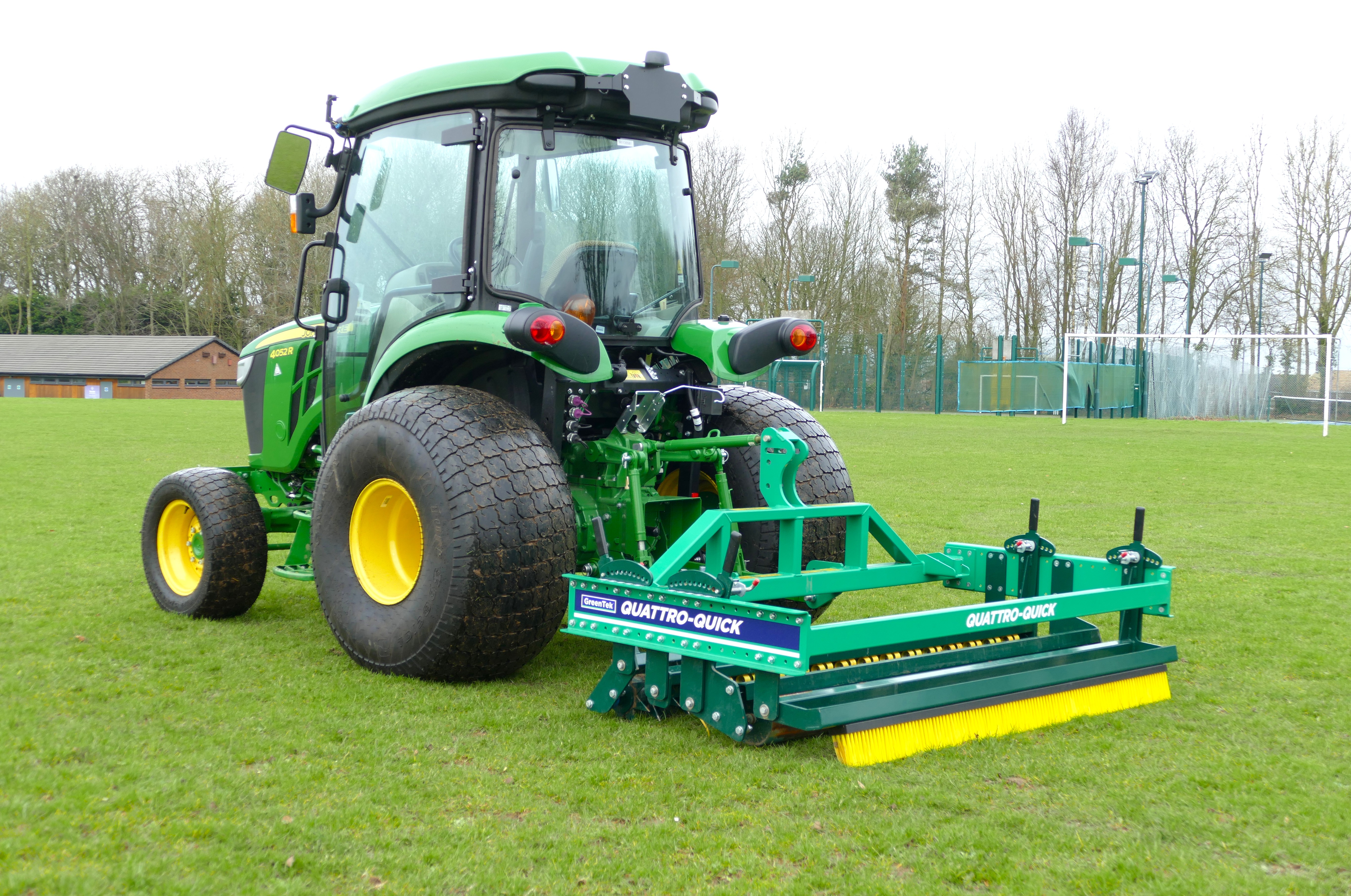 GreenTek Quattro-Quick 4-in-1 sports turf grooming system attached to tractor on football pitch