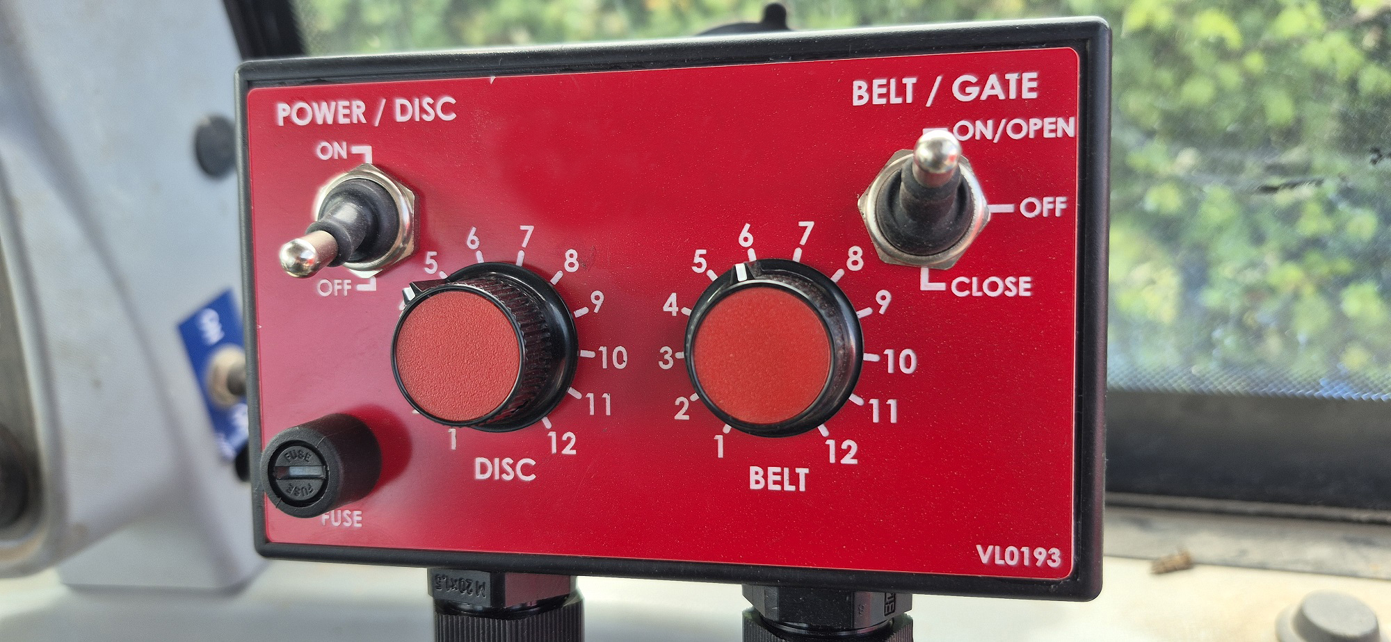 In-cab controls for belt, spinners, and hydraulic flow gate