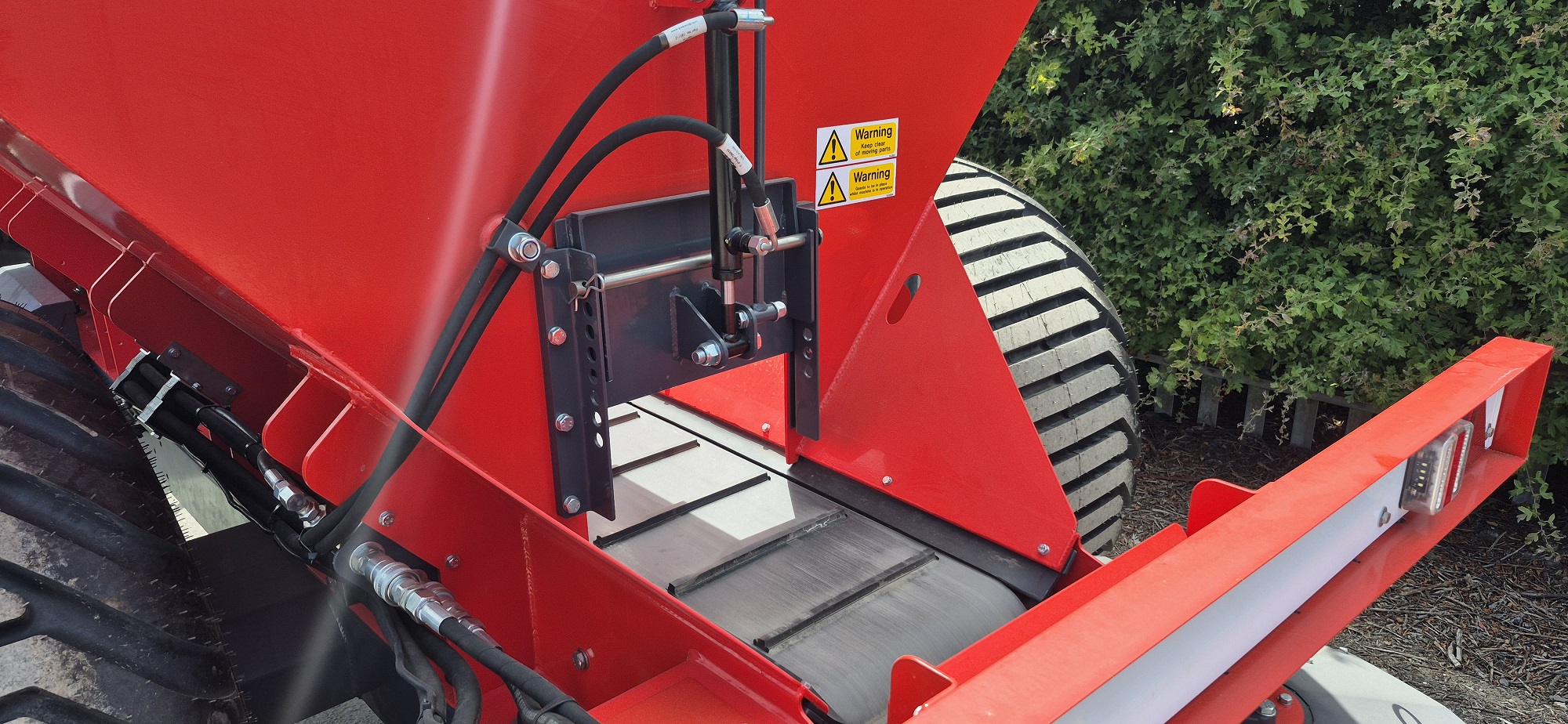 Smooth sided hopper has under-mounted sealing strips for unrestricted flow of sand onto the cleated conveyor
